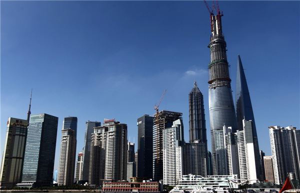 Shanghai Tower, China's tallest building when it's finished, dwarfs nearby skyscrapers in the Lujiazui finance and trade district in Shanghai's Pudong area, July 17, 2013. The structure will be capped soon with a spire, which will bring the dragon-shaped building to a height of 632 meters, dwarfing the 492-meter Shanghai World Financial Center and 421-meter Jinmao Tower. The building will be finished and open by 2015. (Photo/Xinhua)