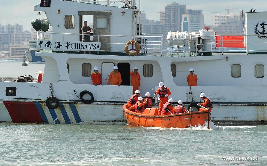 Seamen participate in a maritime fire drill held by the South China Sea Navigation Support Center at the Qiongzhou Strait near Haikou, capital of south China's Hainan Province, July 18, 2013. (Xinhua/Guo Cheng)  