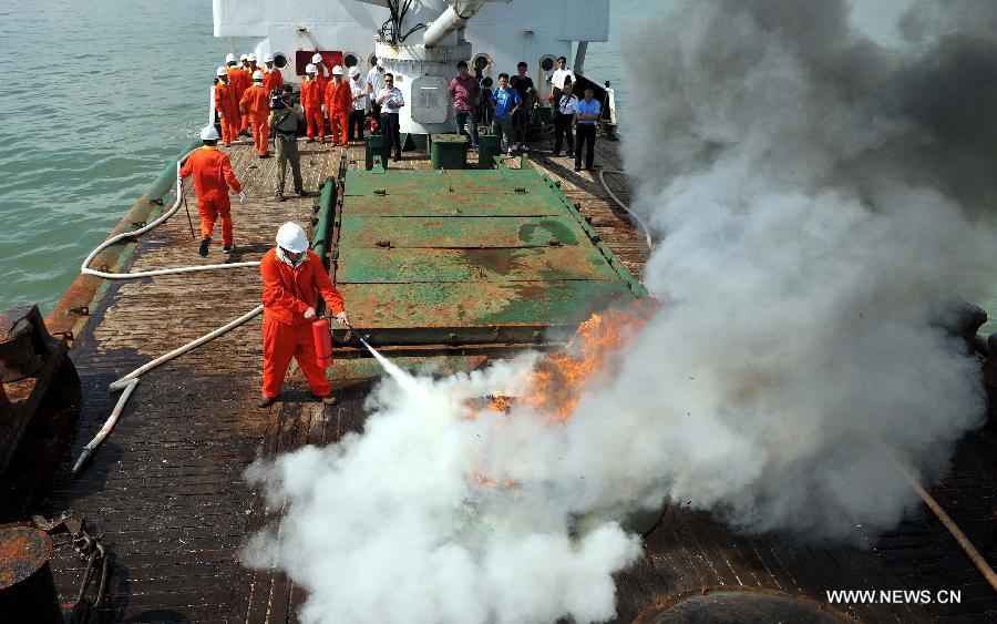 Seamen participate in a maritime fire drill held by the South China Sea Navigation Support Center at the Qiongzhou Strait near Haikou, capital of south China's Hainan Province, July 18, 2013. (Xinhua/Guo Cheng) 