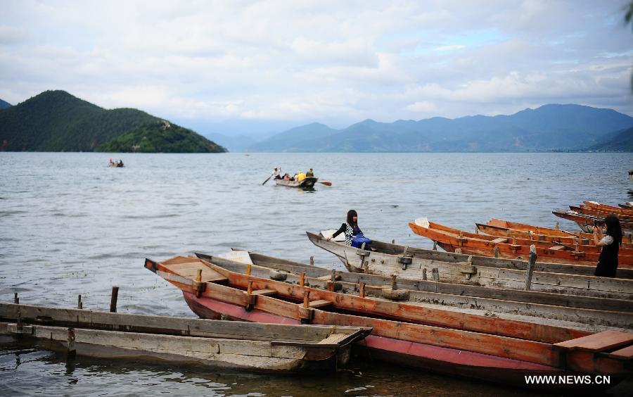 Tourists visit the Lugu Lake in the Yi Autonomous County of Ninglang, southwest China's Yunnan Province, July 17, 2013. Lugu is renowned for its beautiful scenery and the maintenance of the unique matriarchal system observed by the indigenous Mosuo people. (Xinhua/Qin Lang)