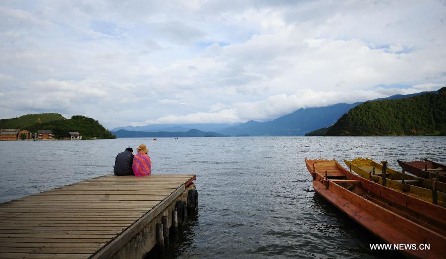 People enjoy themselves on the Lugu Lake in the Yi Autonomous County of Ninglang, southwest China's Yunnan Province, July 17, 2013. Lugu is renowned for its beautiful scenery and the maintenance of the unique matriarchal system observed by the indigenous Mosuo people. . (Xinhua/Qin Lang)