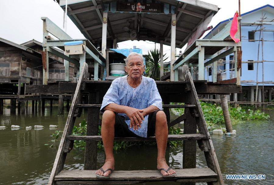 A resident sits in front of his house on a tributary of the Chao Phraya river, Thailand, July 16, 2013. The Chao Phraya river is a major river in Thailand. It flows through Bangkok and then into the Gulf of Thailand. (Xinhua/Gao Jianjun)