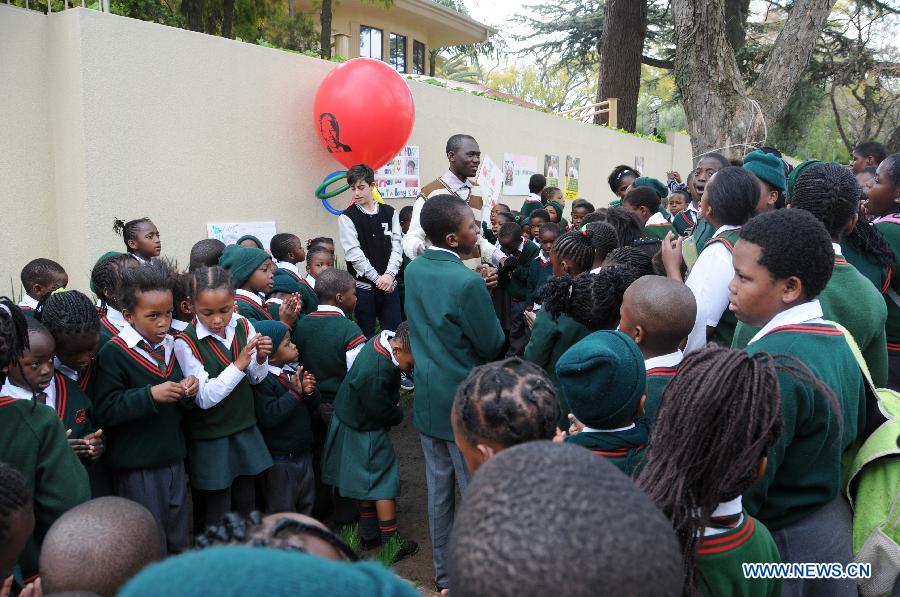 Students sing for Mandela outside his house in Johannesburg, South Africa, on July 18, 2013. South African former president Mandela is steadily improving, according to the Presidency website update released on Thursday. "Madiba remains in hospital in Pretoria but his doctors have confirmed that his health is steadily improving," said the statement. President Jacob Zuma wished the founding father of the nation a happy 95th birthday. (Xinhua/Guo Xinghua)