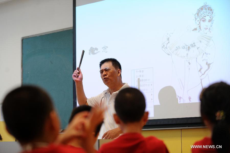 Children are seen at a lecture about Peking Opera given by Zhang Liehu, a national first-class performer, in a youth and children's development center in Hangzhou, east China's Zhejiang Province, July 18, 2013. The lecture is held to enrich children's life during summer vacation.(Xinhua/Ju Huanzong)  