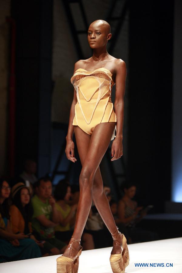 A model presents a creation during a fashion event showcasing works by graduates of the ESMOD (L'Ecole Superieure des Arts et Techniques de la Mode) Beijing, an international fashion institute, in Beijing, China, July 18, 2013. (Xinhua/Hou Dongtao) 