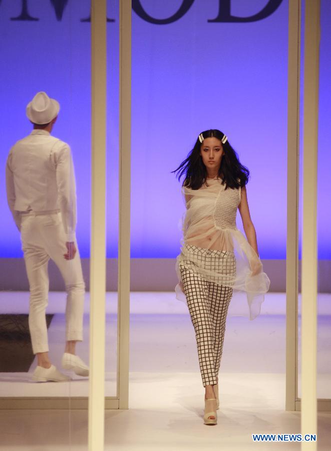 A model presents a creation during a fashion event showcasing works by graduates of the ESMOD (L'Ecole Superieure des Arts et Techniques de la Mode) Beijing, an international fashion institute, in Beijing, China, July 18, 2013. (Xinhua/Hou Dongtao) 