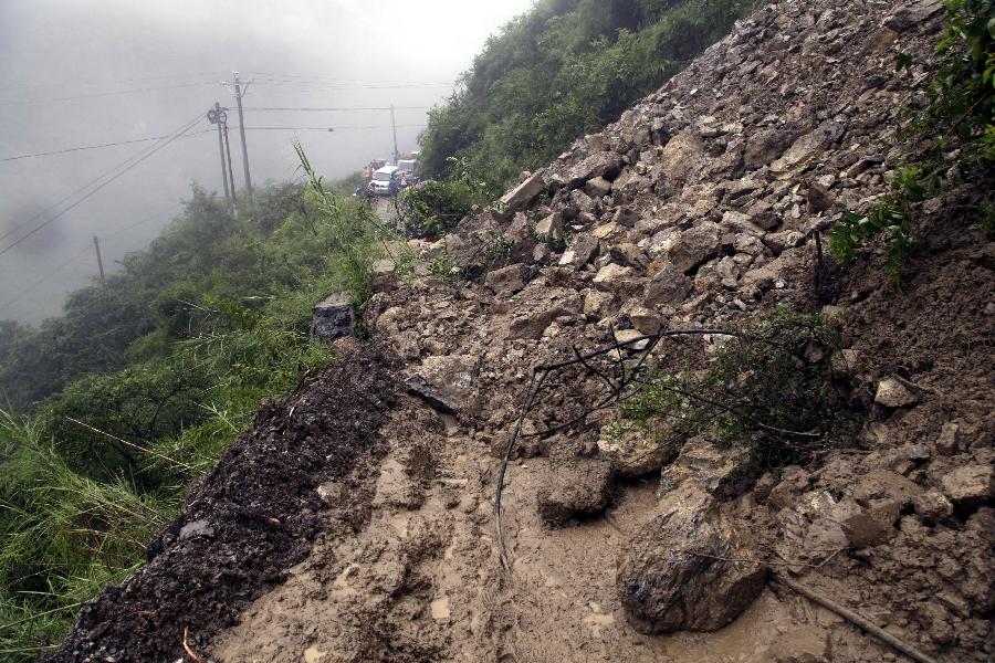 Vehicles are stranded by a mudslide on a country road at Daguan County in Zhaotong City, southwest China's Yunnan Province, July 18, 2013. Torrential rain over the past two days wreaked havoc in the city of Zhaotong. Three people died, 53,100 have been affected, 1,300 evacuated and thousands of hectares of crops damaged in five counties and districts in Zhaotong, said the city's flood control authorities Thursday. (Xinhua/Zhang Guangyu) 