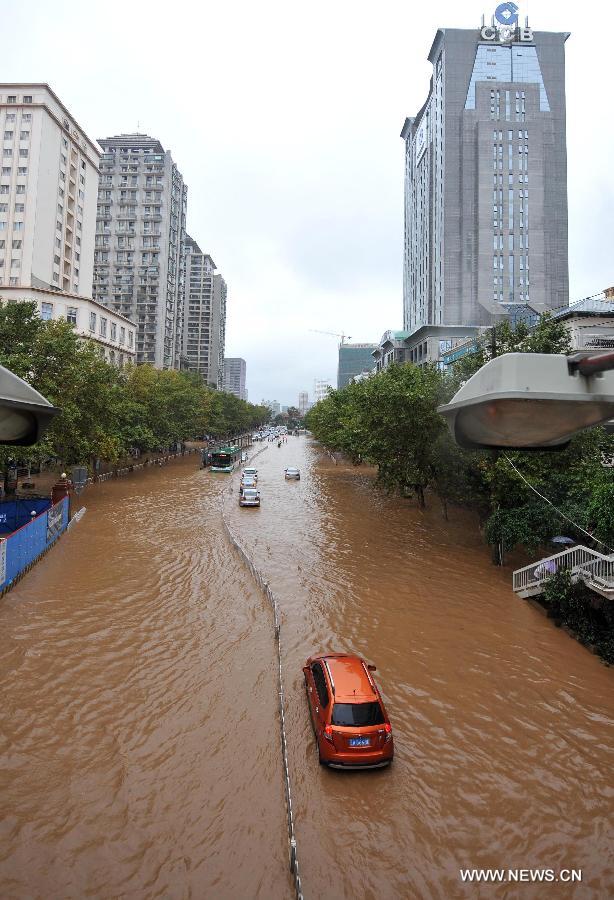 Cars drive on the flooded Jinbi Road in Kunming, capital of southwest China's Yunnan Province, July 19, 2013. Kunming was hit by a heavy rainstorm from Thursday to Friday. Kunming's meteorologic center on Friday issued a blue alert for rainstorm. (Xinhua/Lin Yiguang)