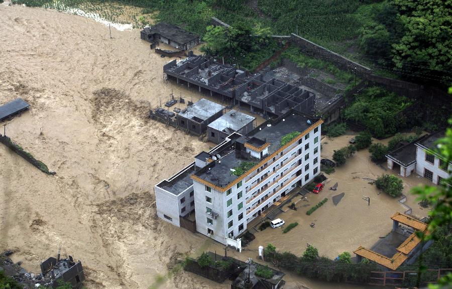 A swollen river runs through a valley, bringing damages at Daguan County in Zhaotong City, southwest China's Yunnan Province, July 18, 2013. Torrential rain over the past two days wreaked havoc in the city of Zhaotong. Three people died, 53,100 have been affected, 1,300 evacuated and thousands of hectares of crops damaged in five counties and districts in Zhaotong, said the city's flood control authorities Thursday. (Xinhua/Zhang Guangyu)