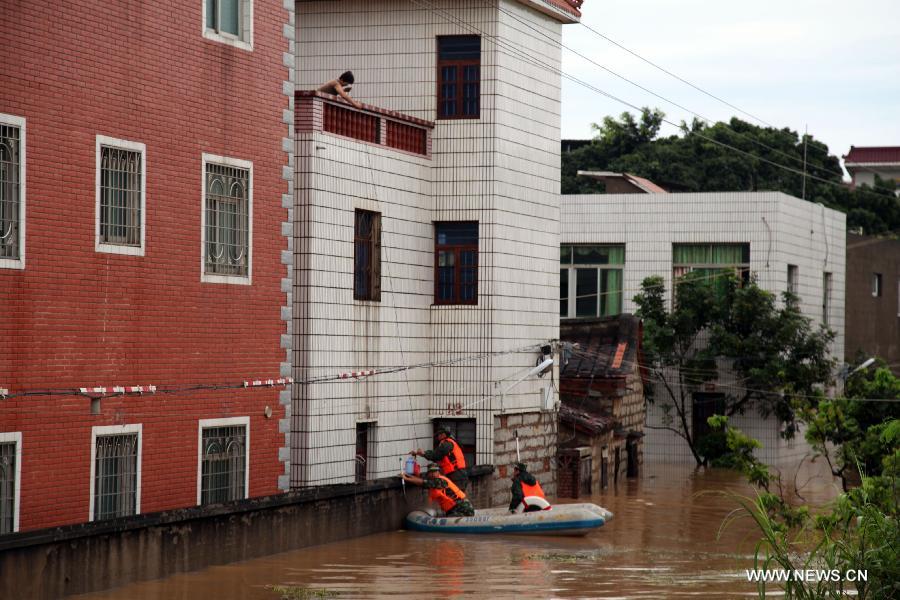 Rescuers evacute a local from the waterlogged Houjing Village at Haicang District in Xiamen, southeast China's Fujian Province, July 19, 2013. Tropical storm Cimaron made landfall in the province Thursday night, bringing rainstorms to Xiamen. Over 40 villagers were evacuated after the low-lying village was flooded. (Xinhua) 