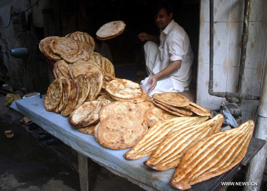 Vendors wait for customers at a shop during the fasting month of Ramadan in northwest Pakistan's Peshawar, July 19, 2013. Muslims around the world refrain from eating, drinking and smoking from dawn to dusk during the fasting month of Ramadan. (Xinhua/Ahmad Sidique)