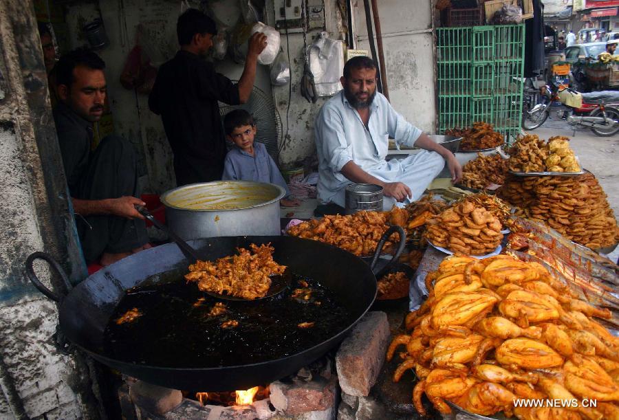 Vendors wait for customers at a shop during the fasting month of Ramadan in northwest Pakistan's Peshawar, July 19, 2013. Muslims around the world refrain from eating, drinking and smoking from dawn to dusk during the fasting month of Ramadan. (Xinhua/Ahmad Sidique)