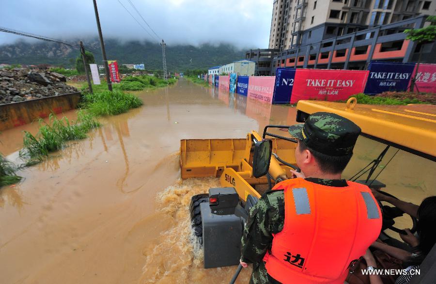 Rescuers and journalists take a forklift to enter severely-flooded Gangwei Township in Longhai of Zhangzhou City, southeast China's Fujian Province, July 19, 2013. Tropical storm Cimaron made its landfall in Fujian Thursday evening, bringing heavy rain and strong gales to southern part of the province. Xiamen, Zhangzhou, Quanzhou and Putian were severely affected by the storm, with the rainfall in some regions like Longhai reaching 520 millimeters on Friday. About 123,000 residents were afflicted by the storm and no casualties have been reported yet. (Xinhua/Wei Peiquan) 