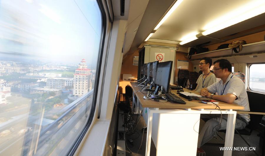 Staff workers work on a test bullet train moving on Xiangtang-Putian Railway, or Xiangpu Railway, during a joint debugging and commissioning process, July 17, 2013. The 632-kilometer-long railway, which links Xiangtang Township in Nanchang, capital of east China's Jiangxi Province, and Putian City in southeast China's Fujian Province, is expected to open to traffic by the end of this September after all debugging and commissioning finishes. The Xiangpu Railway, which will be one of the key transportation arteries for both travellers and goods in this area after it is opened to traffic, will also be the first railway running through seven districts and counties in Jiangxi and Fujian. (Xinhua/Chen Chunyuan)