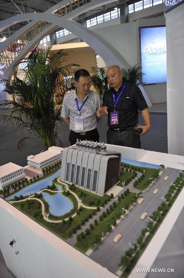 Visitors look at scaled model of a green building at the first China Ecological Products (Technologies) Expo in Guiyang, capital of southwest China's Guizhou Province, July 19, 2013. The five-day expo, a key part of the 2013 Eco-Forum Global Annual Conference, kicked off here Friday. More than 260 exhibitors will attend the expo to introduce their advanced concepts and techniques in the filed of ecology. (Xinhua/Ou Dongqu)