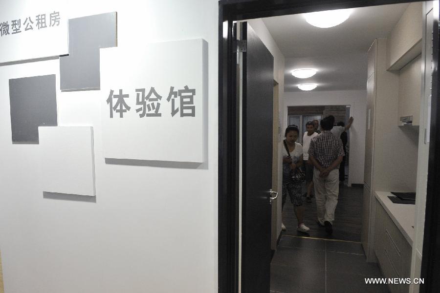 People visit a prototype room of a mini public rental apartment whose usable area covers only 20.62 square meters at the first China Ecological Products (Technologies) Expo in Guiyang, capital of southwest China's Guizhou Province, July 19, 2013. The five-day expo, a key part of the 2013 Eco-Forum Global Annual Conference, kicked off here Friday. More than 260 exhibitors will attend the expo to introduce their advanced concepts and techniques in the filed of ecology. (Xinhua/Ou Dongqu)