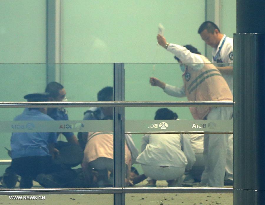 Medical workers and policemen work at an explosion site in T3 terminal of the Beijing Capital International Airport in Beijing, capital of China, July 20, 2013. The explosion occured around 6:30 p.m. near the B exit of the terminal. According to eyewitnesses, a disabled person ignited bombs on himself. The casualty is unknown yet. (Xinhua/Chen Jianli)