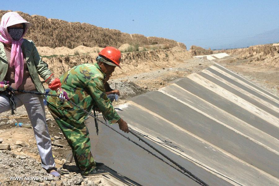 Workers work at the construction site for protecting the Great Wall in Shandan County, northwest China's Gansu Province, July 19, 2013. This year, the local authorities has allocated more than 30 million yuan (about 4.89 million U.S. dollars) for the protection of the Great Wall in Shandan County, which was built in the Ming Dynasty (1368-1644) and has a length of 88 kilometers. (Xinhua/Yin Xubao)