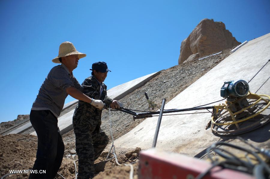 Workers work at the construction site for protecting the Great Wall in Shandan County, northwest China's Gansu Province, July 19, 2013. This year, the local authorities has allocated more than 30 million yuan (about 4.89 million U.S. dollars) for the protection of the Great Wall in Shandan County, which was built in the Ming Dynasty (1368-1644) and has a length of 88 kilometers. (Xinhua/Chen Bin)