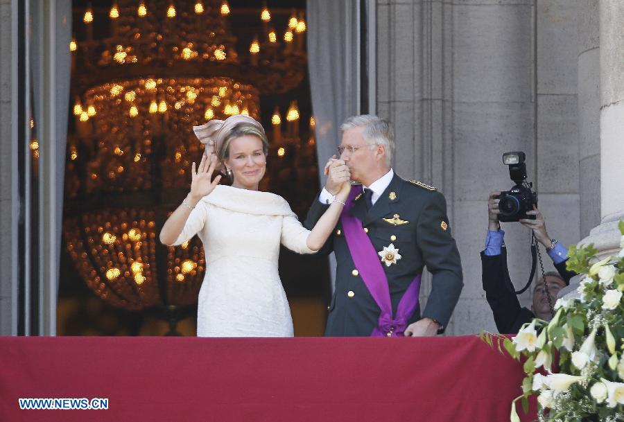 Belgium's newly sworn in King Philippe kisses Queen Mathilde's hand on the balcony of Royal Palace in Brussels, capital of Belgium, on July 21, 2013, the country's national day. Prince Philippe was sworn in before parliament as Belgium's seventh king on Sunday, after his father Albert II abdicated. (Xinhua/Ye Pingfan)