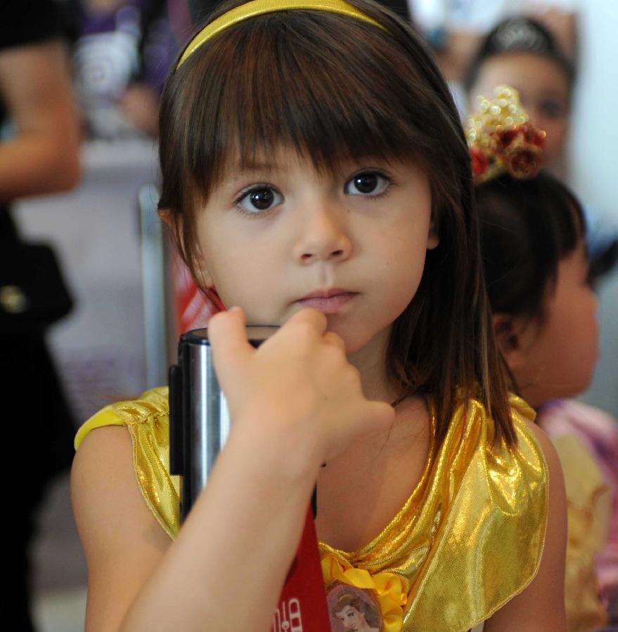 A little girl waits to compete in the final of "Sofia the First" Little Princess Recruitment in south China's Hong Kong, July 21, 2013. "Sofia the First" is a television cartoon series produced by Disney. In total 25 little girls competed during the final recruitment organized by Disney Junior channel. (Xinhua/Zhao Yusi)