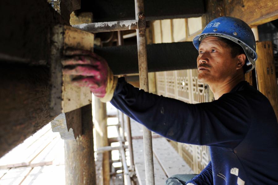 A worker fixes beams inside a gate tower of the Jiayu Pass, the starting point of a section of the Great Wall constructed during the Ming Dynasty (1368-1644) in Jiayuguan City, northwest China's Gansu Province, July 21, 2013. Built in 1372, the Jiayu Pass also served as a vital passage on the ancient Silk Road. It was listed on UNESCO's World Heritage List in 1987. China has poured 2.03 billion yuan (about 328 million US dollars) in maintaining the Jiayu Pass, also including the construction of a world culture heritage inspection center and a heritage protection and display project at the end of 2011. The local cultural relics bureau announced Sunday that the maintenance project, the largest one since the Pass was set up, has entered the critical stage. (Xinhua/Chen Bin) 