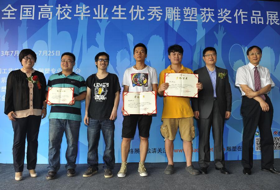 Honored guests and students win the honorable nominee awards pose for a group picture at the award ceremony of an exhibition of the awarded sculpture works of 2013 college graduates in Beijing, capital of China, July 21, 2013. These awarded works are presented to the public from July 21, 2013 to July 25, 2013 here. (Xinhua/Lu Peng)