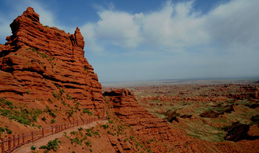 Photo taken on July 20, 2013 shows the scenery of Danxia landform at Pingshan Lake scenic area in Zhangye City, northwest China's Gansu Province. Danxia, which means "rosy cloud", is a special landform formed from reddish sandstone that has been eroded over time into a series of mountains surrounded by curvaceous cliffs and many unusual rock formations. (Xinhua/Wang Jiang)