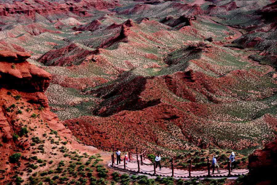 Tourists view the scenery of Danxia landform at Pingshan Lake scenic area in Zhangye City, northwest China's Gansu Province, July 20, 2013. Danxia, which means "rosy cloud", is a special landform formed from reddish sandstone that has been eroded over time into a series of mountains surrounded by curvaceous cliffs and many unusual rock formations. (Xinhua/Wang Jiang)