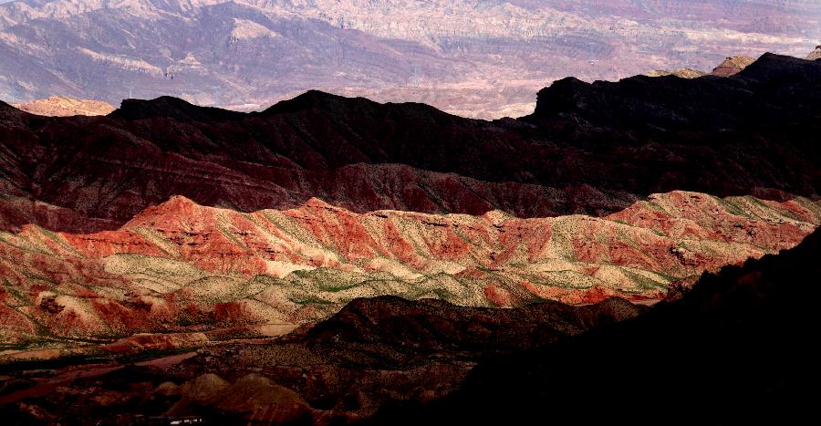 Photo taken on July 20, 2013 shows the scenery of Danxia landform at Pingshan Lake scenic area in Zhangye City, northwest China's Gansu Province. Danxia, which means "rosy cloud", is a special landform formed from reddish sandstone that has been eroded over time into a series of mountains surrounded by curvaceous cliffs and many unusual rock formations. (Xinhua/Wang Jiang)