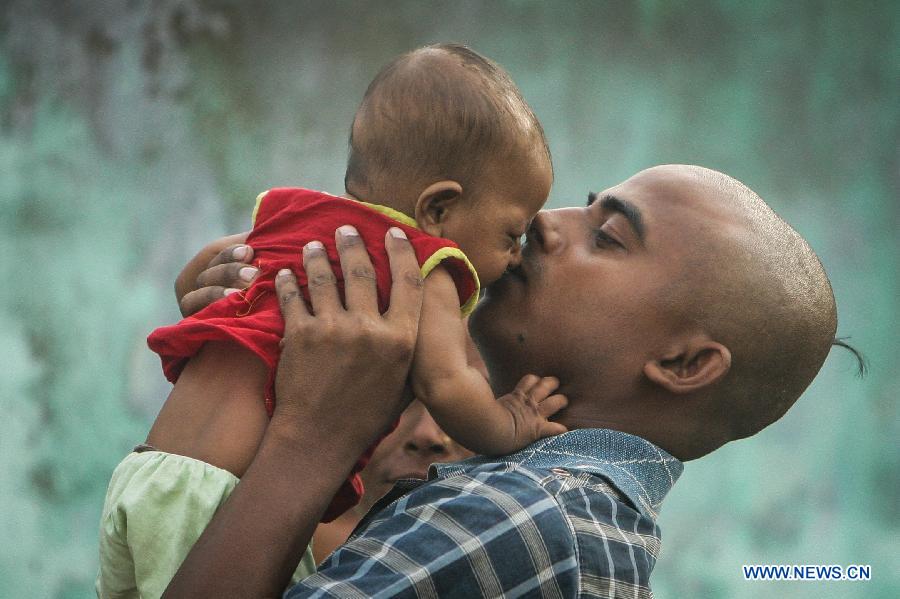 A man, whose daughter was killed in a mass food poisoning, kisses his another daughter in the village of Gandaman, Saran District of eastern Indian state of Bihar, July 20, 2013. At least 23 children, all below 12 years, were confirmed dead due to food poisoning after eating a free mid-day school meal in the eastern Indian state of Bihar on July 16, 2013. (Xinhua/Zheng Huansong) 