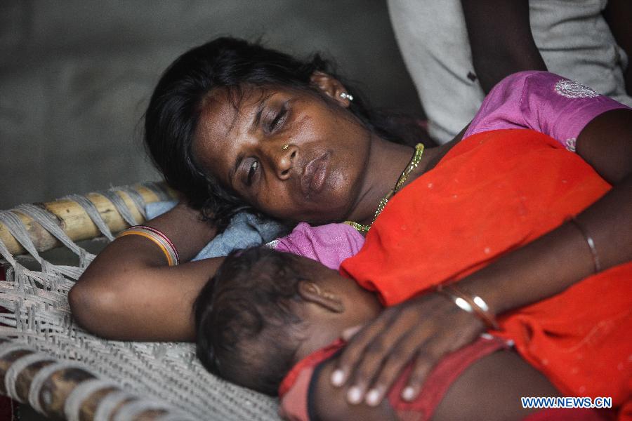 A woman, whose daughter was killed in a mass food poisoning, accompanies her another kid in the village of Gandaman, Saran District of eastern Indian state of Bihar, July 21, 2013. At least 23 children, all below 12 years, were confirmed dead due to food poisoning after eating a free mid-day school meal in the eastern Indian state of Bihar on July 16, 2013. (Xinhua/Zheng Huansong) 