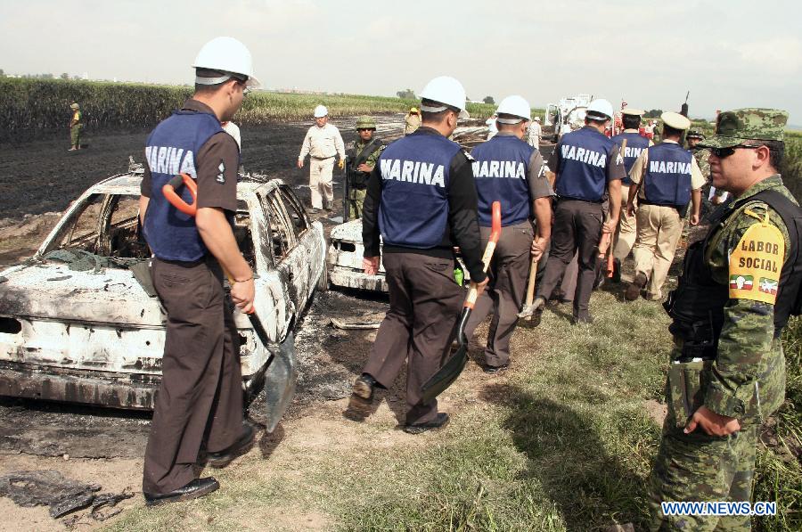 Elements of the Mexican Navy work near the place where a fire was registered in a duct of the Mexican oil company Pemex, in the Tonanitla municipality, in the State of Mexico, Mexico, on July 21, 2013. The oil spill and fire in Tonanitla were caused by a clandestine outlet to extract the fuel, Pemex confirmed in a statement. Until now, the authorities have reported 6 people wounded, two of them belonging to the fire brigade and four municipal policemen. (Xinhua/Juan Carlos Villa)