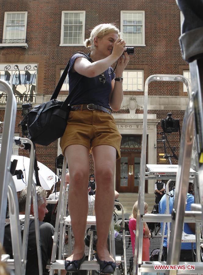 A reporter takes a photo on a ladder outside the Lindo Wing of St. Mary's Hospital in London, July 22, 2013. The nation awaits news of a new royal baby. The nation awaits news of a new royal baby as Prince William's wife Kate has gone into labour and been admitted to St. Mary's Hospital for the birth of the couple's first child. (Xinhua/Yin Gang)