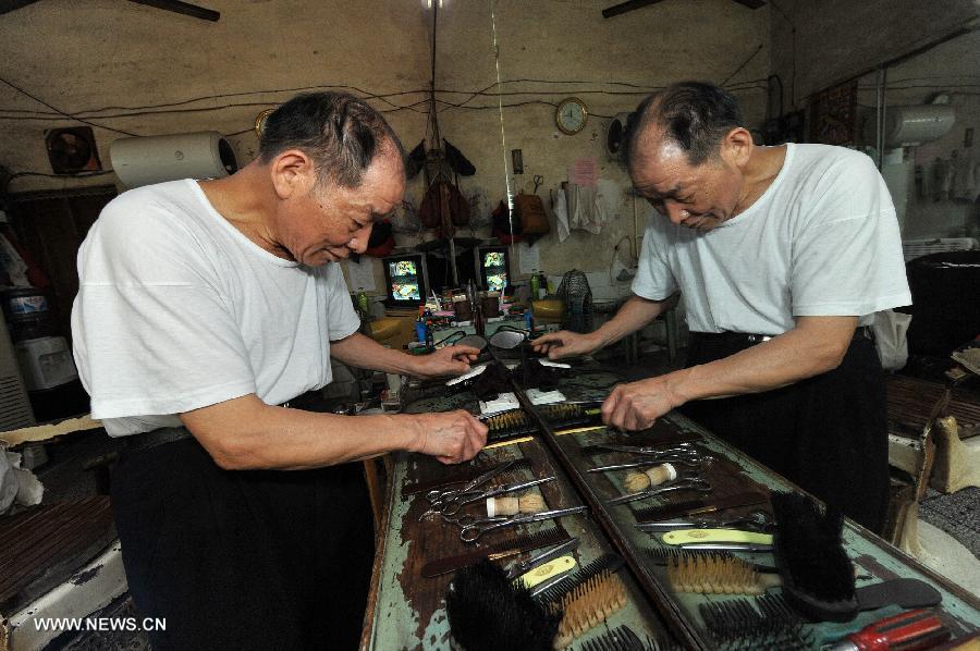 Ou Shubin sorts tools at his old-fashioned barbershop at No. 76, Meihua Road in Ningxiang County, central China's Hunan Province, July 21, 2013. Affectionately known as Ou Die, or Daddy Ou in the neighborhood, the 78-year-old barber has been in the business for 66 years and run the current shop for 33 years, offering traditional services to old customers. (Xinhua/Long Hongtao) 