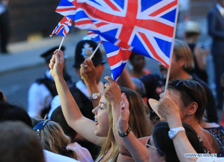 People cerebrate the birth of Prince William and his wife Catherine's baby boy in front of St Mary's Hospital in London, on July 22, 2013. Britain's Duchess of Cambridge Kate gave birth to a boy on Monday afternoon. (Xinhua/Yin Gang)