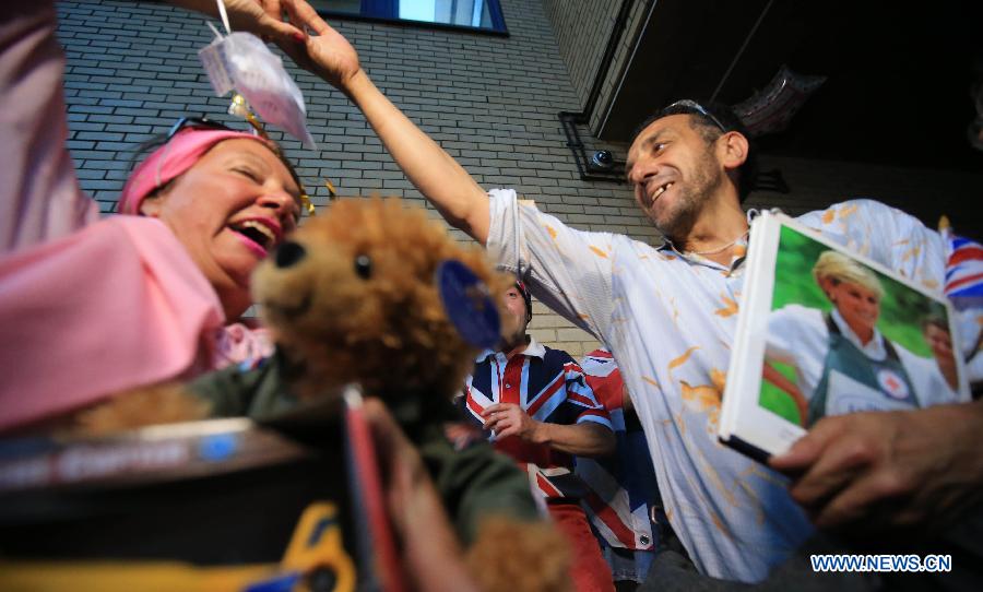 People cerebrate the birth of Prince William and his wife Catherine's baby boy in front of St Mary's Hospital in London, on July 22, 2013. Britain's Duchess of Cambridge Kate gave birth to a boy on Monday afternoon. (Xinhua/Yin Gang)