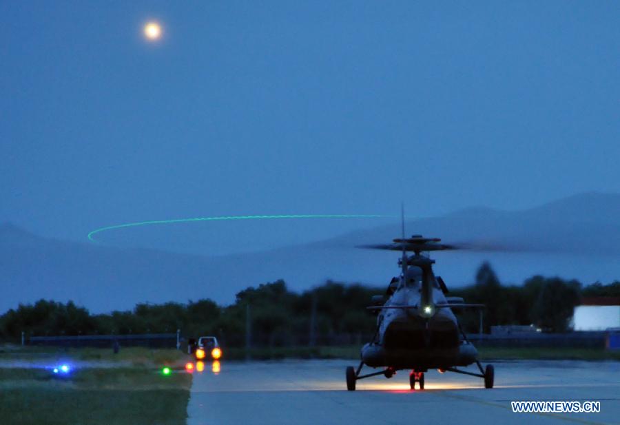 A helicopter of China's PLA Air Force takes part in a night flight training at an airport in Lhasa, capital of southwest China's Tibet Autonomous Region, July 22, 2013. This is the first time for the PLA Air Force to hold such training. (Xinhua/Li Liangfeng)