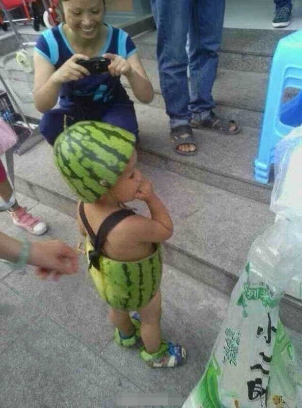 A woman takes photo of the baby in the skin of half a watermelon in Wenzhou, east China's Zhejiang province. (Photo/ people.com.cn)