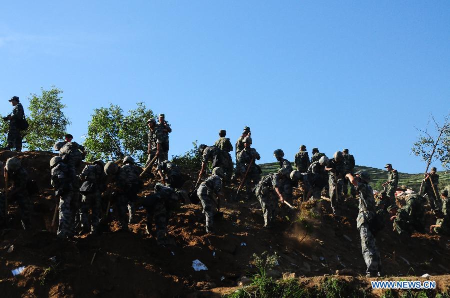 Soldiers take part in a rescue operation after a landslide triggered by a 6.6-magnitude quake in Yongguang Village, Meichuan Town, Minxian County, northwest China's Gansu Province, July 22, 2013. At least nine villagers in Yongguang were killed in the quake and 12 others were burried in the landslide. The rescue work is underway. (Xinhua/Tu Guoxi) 