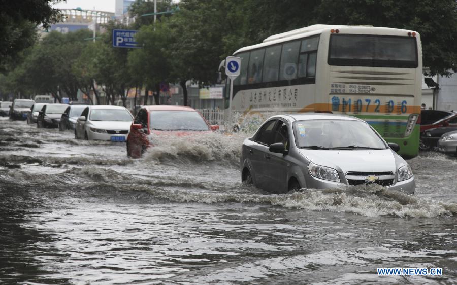 Vehicles run on a flooded road in Binzhou City, east China's Shandong Province, July 23, 2013. Heavy rainfall hit parts of the province in these two days. (Xinhua/Liu Chunying)