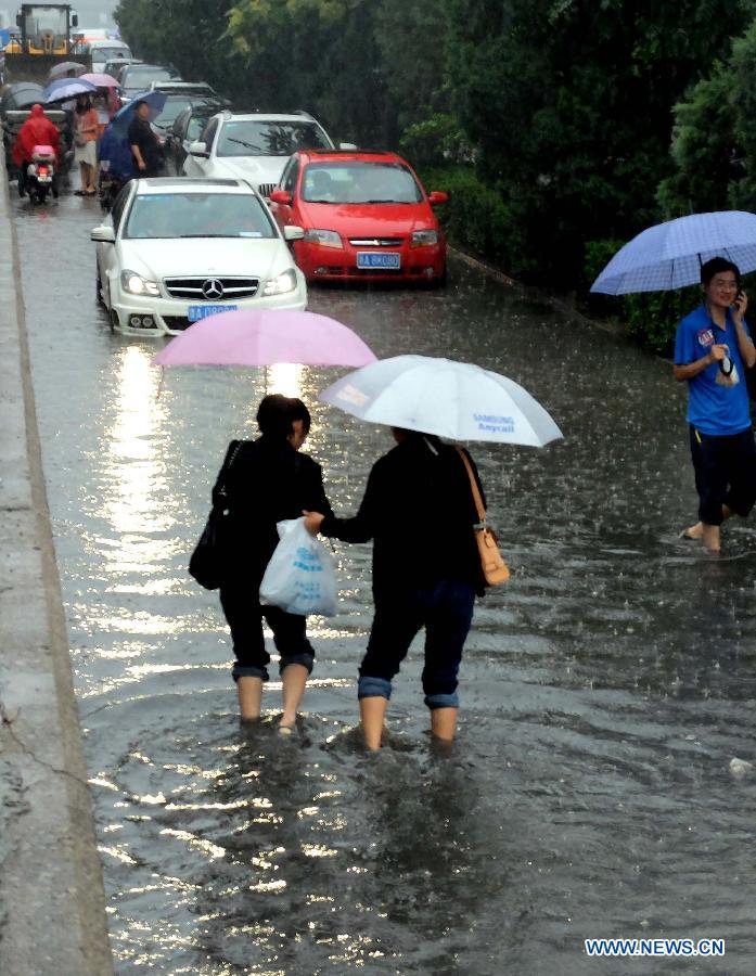 Traffic is disrupted on the waterlogged Shengchan Road in Jinan, capital of east China's Shandong Province, July 23, 2013. A heavy rainfall hit Jinan on Tuesday. (Xinhua/Xu Suhui)