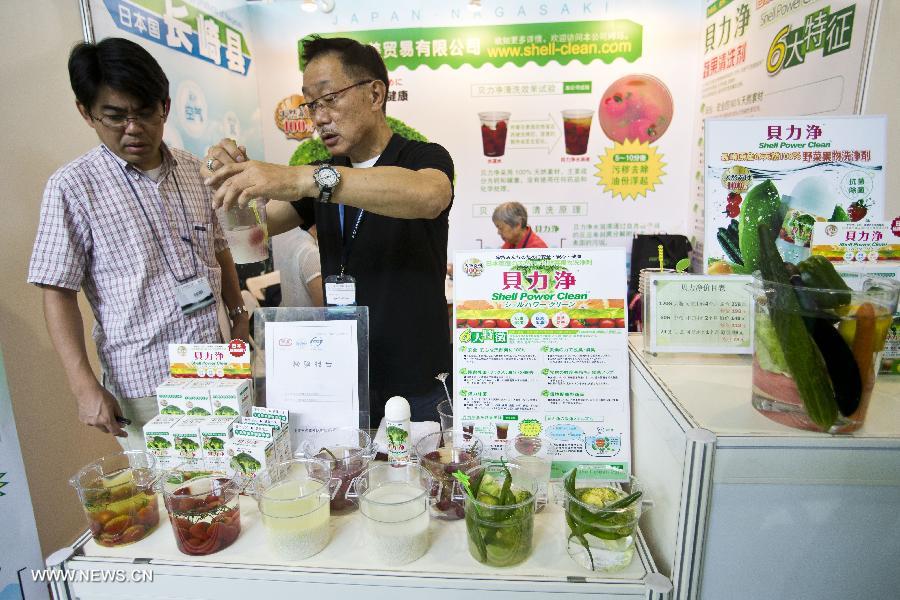 An exhibitor shows to a visitor a detergent made from seashells at the 13th China International Environment Protection Exhibition & Conference in Beijing, capital of China, July 23, 2013. The four-day exhibition kicked off on Tuesday, attracting around 500 enterprises from more than 20 countries and regions. (Xinhua/Zhao Bing)