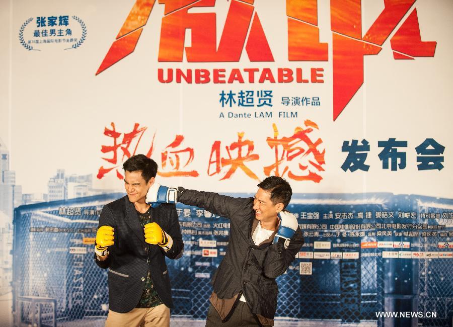 Actor Nick Cheung (R) and actor Eddie Peng pose for photos during the press conference of the movie "Unbeatable" in Beijing, capital of China, July 23, 2013. The movie "Unbeatable" which won both the Golden Goblet for best actor and actress in the 16th Shanghai International Film Festival will hit the screen on Aug. 16. (Xinhua/Li Yan)