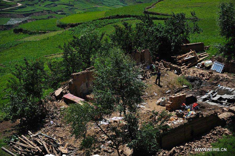 A villager is seen at her quake-hit home in Yongguang Village of Minxian County, northwest China's Gansu Province, July 23, 2013. The death toll has climbed to 94 in the 6.6-magnitude earthquake which jolted a juncture region of Minxian County and Zhangxian County in Dingxi City Monday morning. (Xinhua/Liu Xiao)