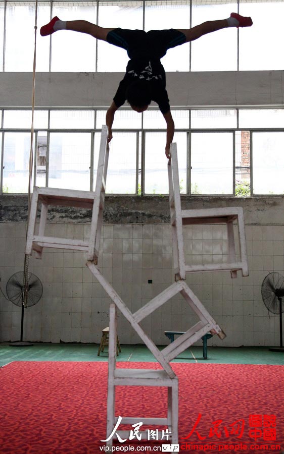 A child in the acrobatic troupe do daily trainings. (vip.people.com.cn/Liang Hongyuan)