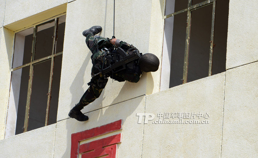 The special operation members from various military area commands of the PLA participate in the anti-terrorism and 40 kilometers orienteering parts of the land subjects of the competition on July 21, 2013. They challenged physiological limits in the complex environment, and withstood the test of live-fire contest.  (China Military Online/Li Jing)