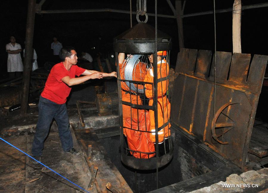 Rescuers are lowered into the Chengcheng sulfur mine in Chengcheng County, northwest China's Shaanxi Province, July 24, 2013. The mine caught fire Tuesday afternoon when 27 people were working underground. Seventeen of them had been rescued, while 10 others were confirmed dead early Wednesday. The fire started on an electric cable when workers were repairing air shaft facilities. (Xinhua/Ding Haitao)