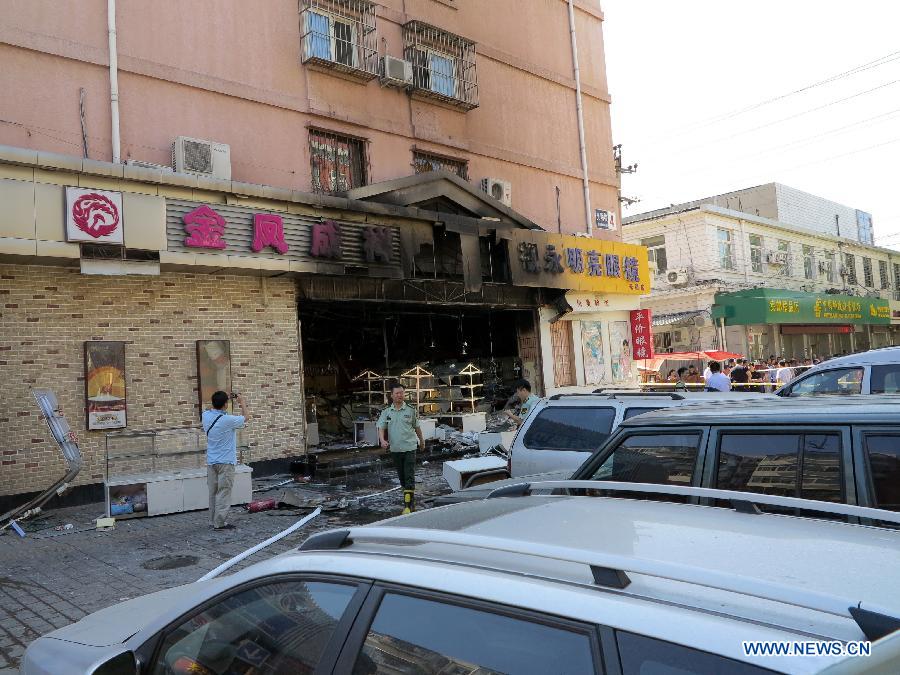 Firemen work at the explosion site of a cake shop on Guangming Road in Beijing, capital of China, July 24, 2013. A gas blast ripped through the cake shop Wednesday morning, leaving a number of people injured and vehicles damaged. (Xinhua/Wang Zhen)