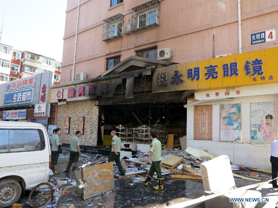 Firemen work at the explosion site of a cake shop on Guangming Road in Beijing, capital of China, July 24, 2013. A gas blast ripped through the cake shop Wednesday morning, leaving a number of people injured and vehicles damaged. (Xinhua/Wang Zhen)